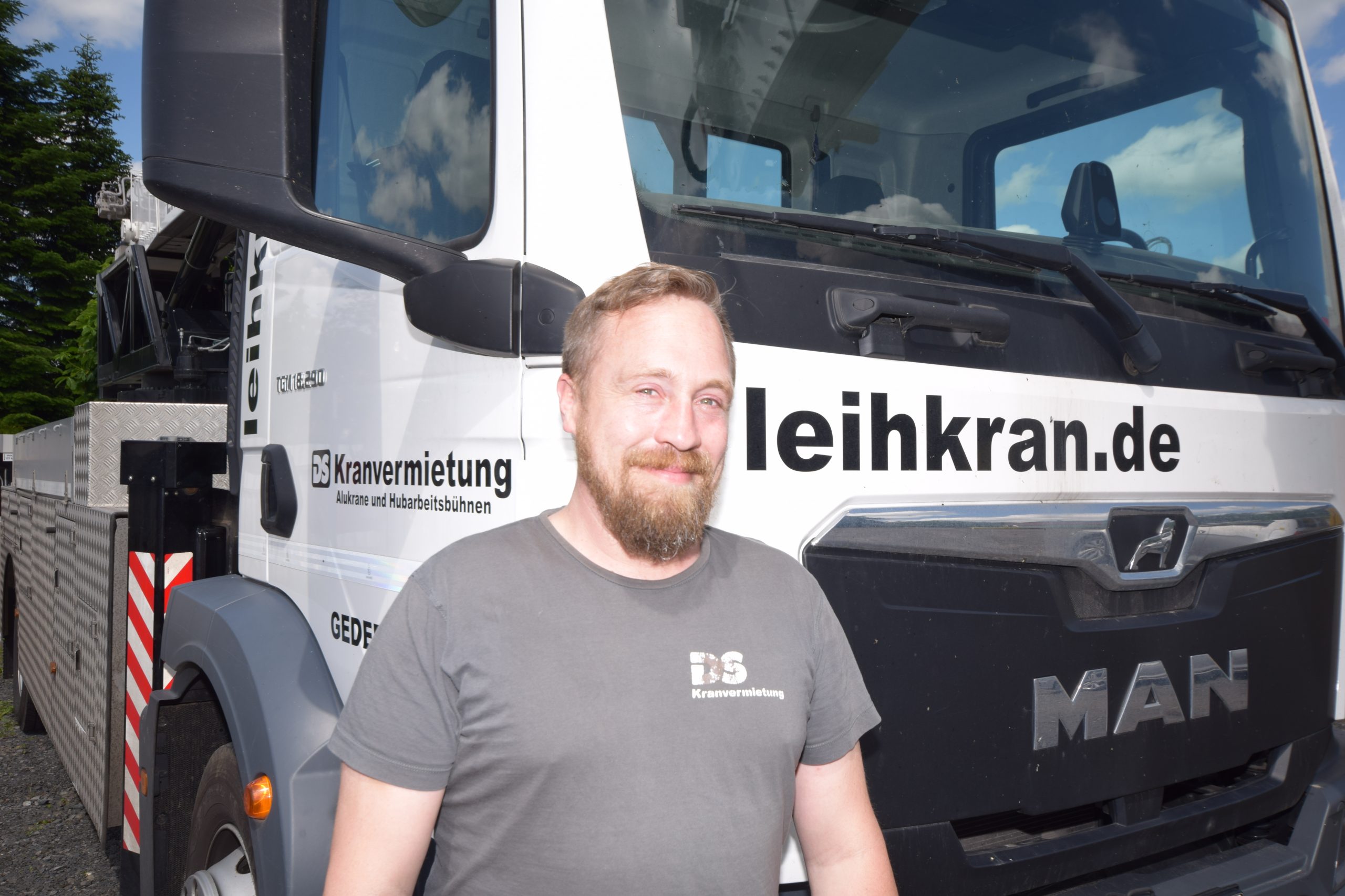 Bild Florian Weber  vor einem Autokran